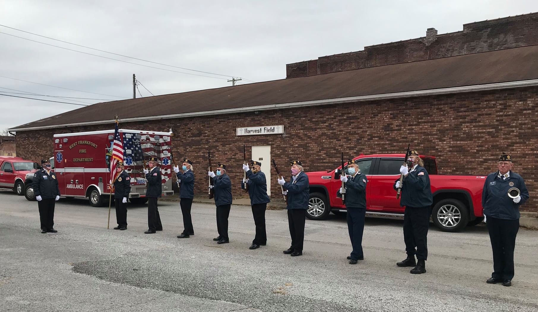 Honor guard standing at attention with rifles outside