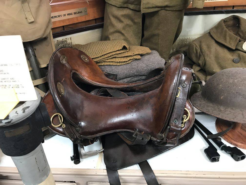 Vintage military saddle and helmet display