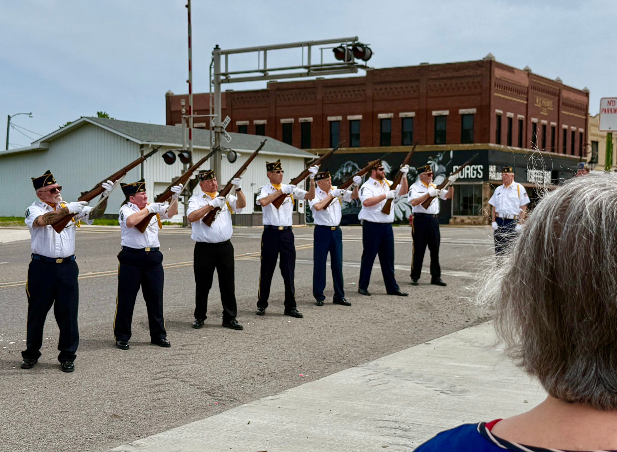 Local honor guard firing rifles in a ceremonial salute